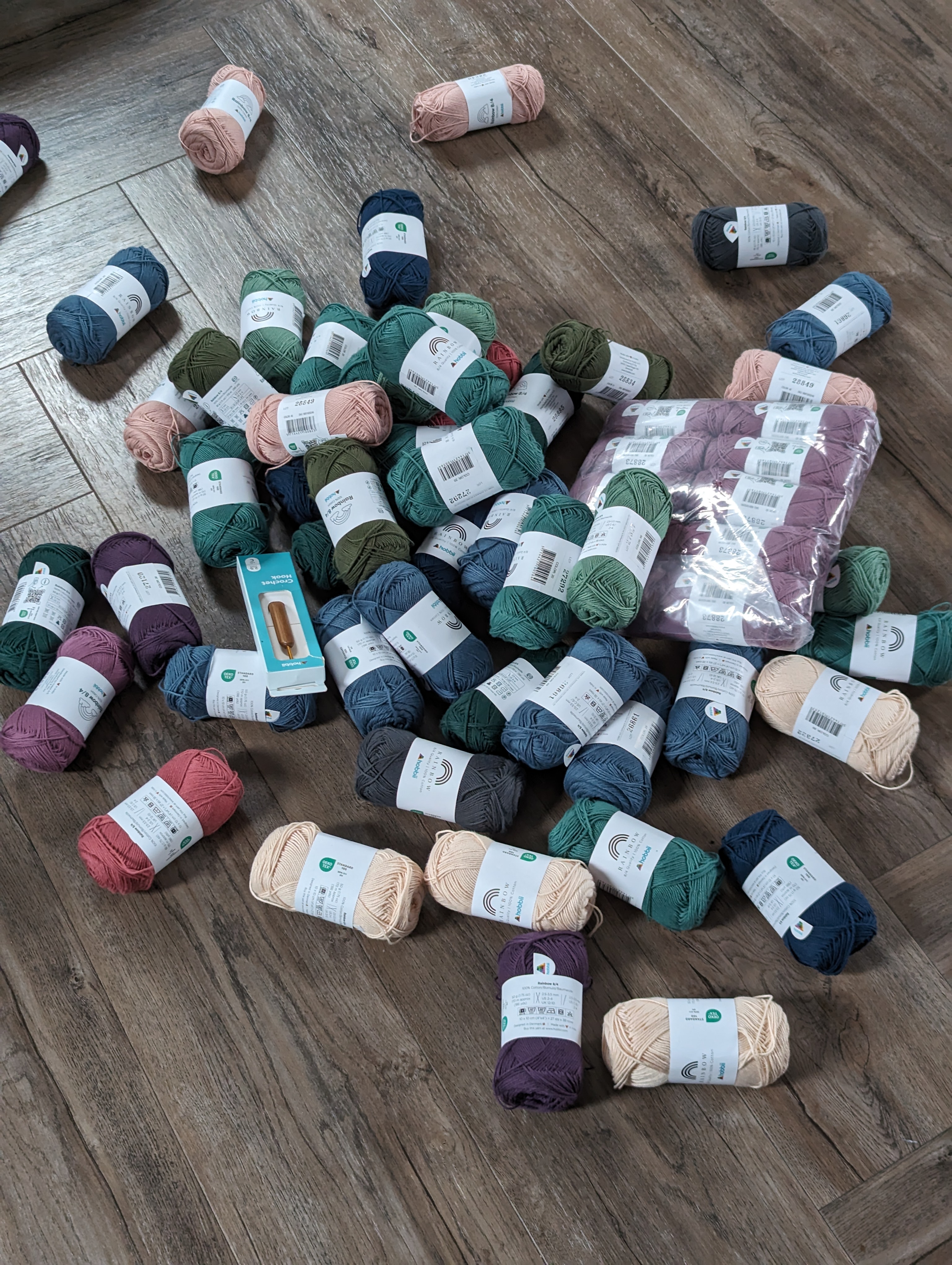 A large pile of cotton yarn balls of various colours